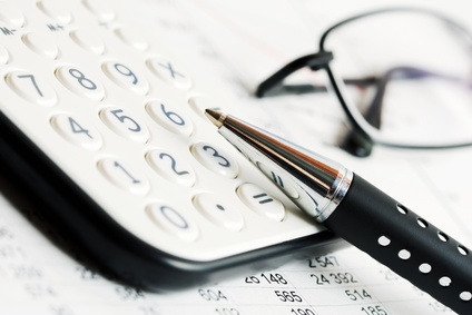 Lunettes, stylo et calculatrice illustrant l'importance du travail dans la genèse de la myopie.