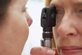 Ophtalmologiste examinant un patient avec un ophtalmoscope